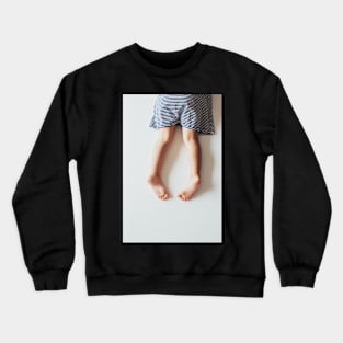 Legs of Small Girl Lying on White Tabletop Crewneck Sweatshirt